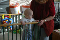 Caroline standing with help from grandma Emmy