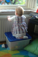  Madeleine climbs on a box to look out through he window